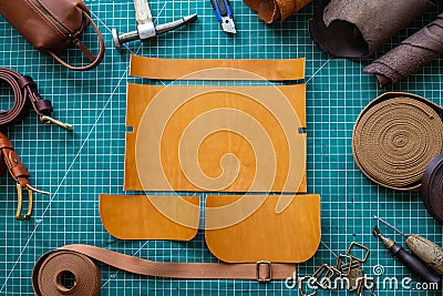 Process cutting scheme of bag with equipment and materials. Male tanner working at leather workshop Stock Photo
