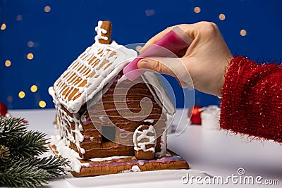 The process of decorating a ginger Christmas house with sugar icing Stock Photo