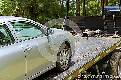 The process of loading a damaged, broken car on a tow truck working in a towing company Stock Photo