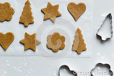 The process of making gingerbread different shaped cookies with rolling pin and sprinkled flour on a light gray background Stock Photo