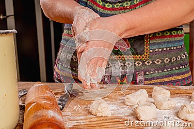 Process of making homemade dumplings. Beautiful young woman making Ukrainian dumplings with potatoes and cheese stuffing. National Stock Photo