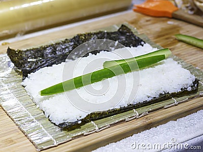 The process of making sushi and rolls with cucumber. Rice on nori sheet Stock Photo