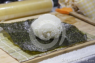 The process of making sushi and rolls with cucumber. Rice on nori sheet Stock Photo