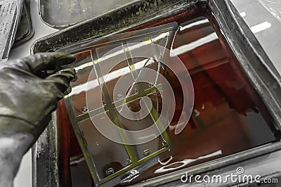 The process of manual washing of polymer printing plates in a special solution dissolving the paint. Work in a printing Stock Photo