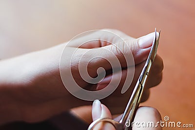 The process of nail clippingl scissors. Hand care concept. Stock Photo