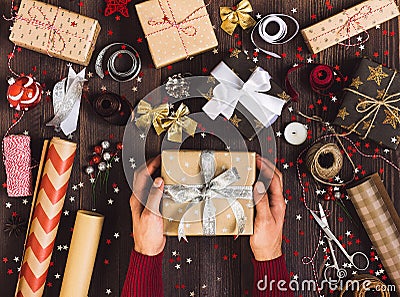 Process of package christmas gift box man in hand holding new year gift box Stock Photo