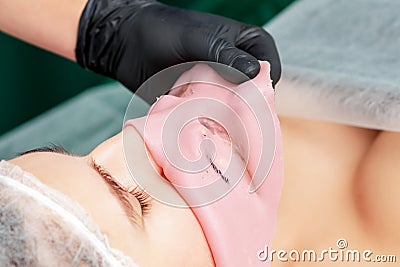 Removing alginate mask from face Stock Photo