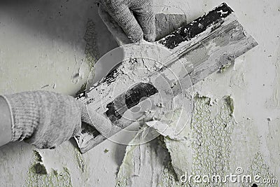 The process of removing old worn out unattractive green from the wall with the help of available tools and a spatula, hands, Stock Photo