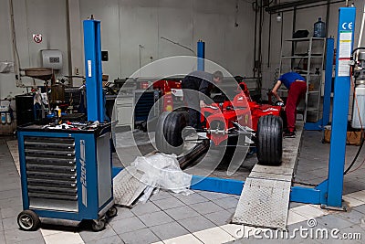 The process of repairing and restoring a red Ferrari Formula 1 car at a pitstop in the service station or a repair workshop on a Editorial Stock Photo