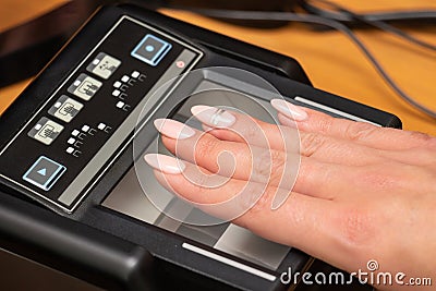 The process of scanning fingerprints during the check at border crossing. Female hand puts fingers to the fingerprint scanner. Stock Photo