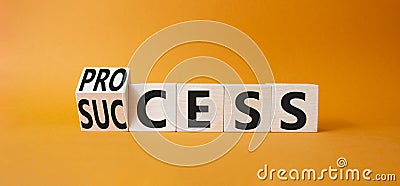 Process and Success symbol. Turned cube with words success and process. Beautiful orange background. Businessman hand. Business Stock Photo
