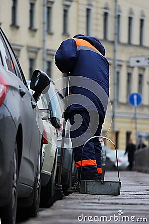 Process of urban street cleaning sweeping. Worker with broom and dust pan Stock Photo