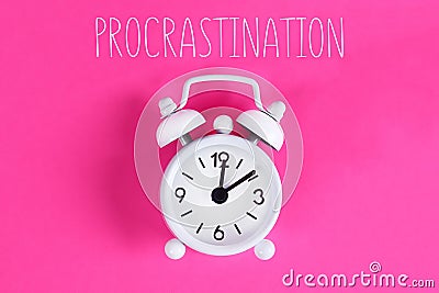 Procrastination, delay, urgency concept. White alarm clock with text procrastination Stock Photo