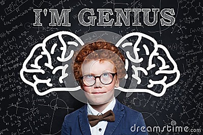 Prodigy child boy with curly ginger hair in glasses. Genius kid Stock Photo