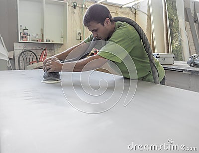 The production of acrylic worktops at a furniture factory. A worker produces acrylic countertops at the factory. A worker polishes Editorial Stock Photo