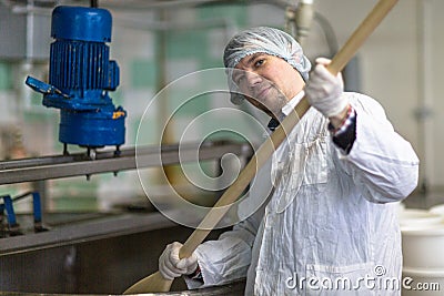 Production of cheese in dairy, worker cheese mixes Stock Photo