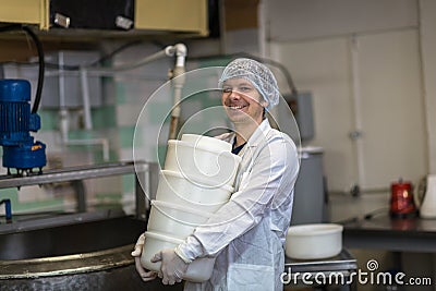 Production of cheese in dairy, worker with forms Stock Photo