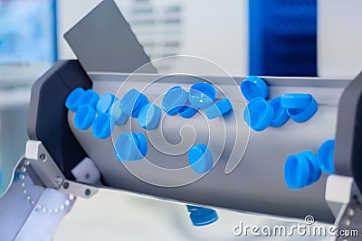 Production line - many blue plastic bottle caps falling from conveyor belt Stock Photo