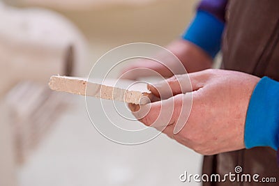 Production, manufacture and woodworking industry concept - close up of senior worker or carpenter with board at Stock Photo
