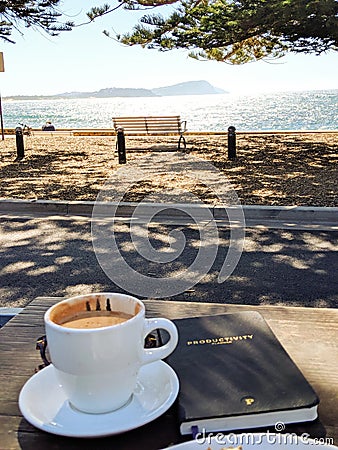 Productivity planning with mocha coffee at beach side cafe Editorial Stock Photo
