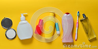 Products for beauty, self-care and hygiene on a yellow pastel background. Shampoo, perfume, lipstick, shower gel, toothbrush. Stock Photo