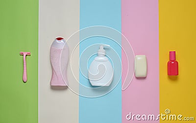 Products for the care of body, hair and personal hygiene on a multi-colored paper background. A bottle of fragrant perfume, lotion Stock Photo