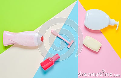 Products for the care of body, hair and personal hygiene on a multi-colored paper background. A bottle of fragrant perfume, lotion Stock Photo