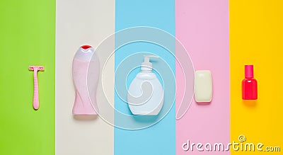Products for the care of body, hair and personal hygiene on a multi-colored paper background. A bottle of fragrant perfume, lotion Stock Photo