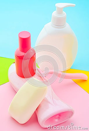 Products for the care of body, hair and personal hygiene on a multi-colored paper background. A bottle of fragrant perfume Stock Photo