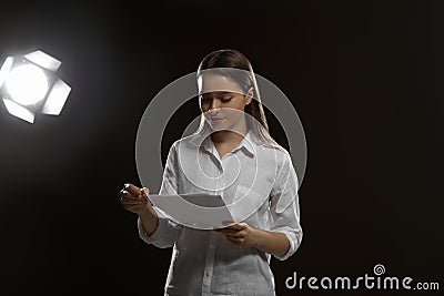 Professional actress reading script during rehearsal in theatre Stock Photo