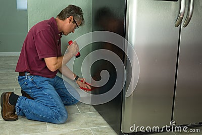 A professional appliance repair service technician man repairing Stock Photo