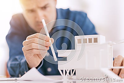 Professional architect working at office desk, he is assembling an architectural model, design and architecture concept Stock Photo