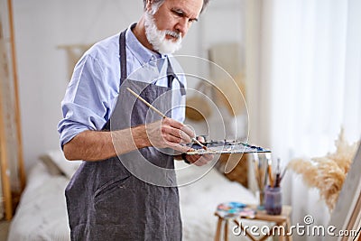 professional artist man is drawing on easel canvas Stock Photo