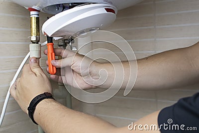 The boiler repairman checks the electronics in the water heater. Professional assistance and technical support concept Stock Photo