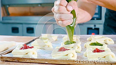 Professional baker adding jam on top of sweet baking before put it into oven Stock Photo