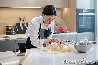 Professional Baker Girl Makes Final Touches in Cooking Bread. Stock Photo