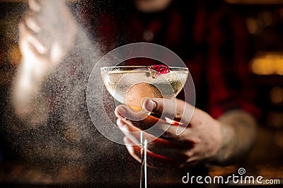 Professional bartender spraying on a delicious Twinkle cocktail in the bar Stock Photo