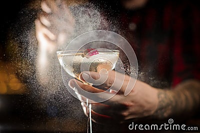 Professional bartender spraying with flavor on a Twinkle cocktail in the bar Stock Photo