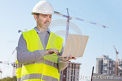 Professional builder typing on computer Stock Photo