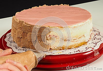 Professional cake baker piping chocolate cream onto cake Stock Photo