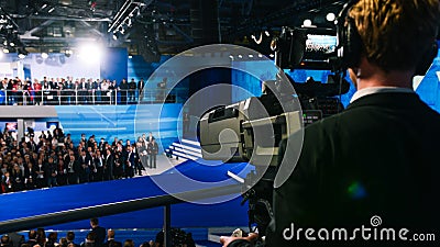 A professional cameraman shoots a crowd of people on the studio 4K camera. Signal transmission over long distances via Editorial Stock Photo