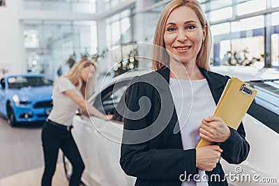 Professional car dealer helping her female customer Stock Photo