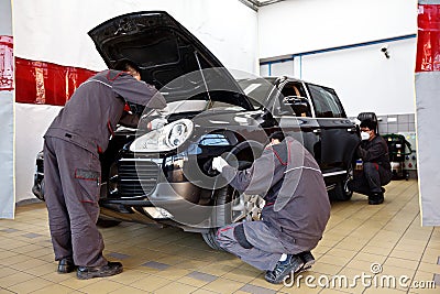 Professional car mechanics working in auto repair service stations. Editorial Stock Photo