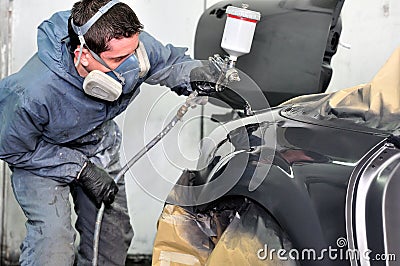 Professional car painter working at a vehicle. Stock Photo