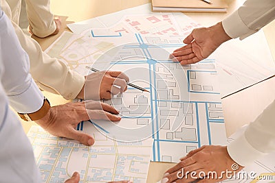 Professional cartographers working with cadastral map at table, closeup Stock Photo