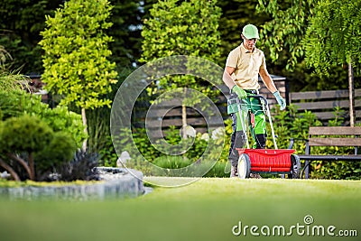 Professional Gardener with Lawn and Garden Seed Spreader Stock Photo