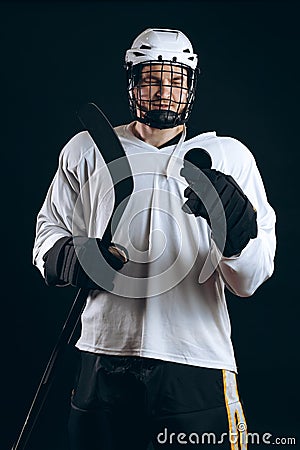 Handsome hockey player. Smiling at camera isolated on black background. Stock Photo