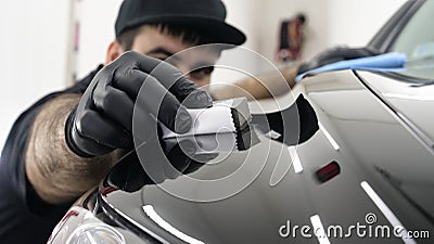 Professional ceramics handler apply different layers to the car using an applicator sponge, fiber immediately checking the effec Stock Photo