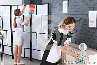 Professional chambermaids in uniform cleaning up Stock Photo