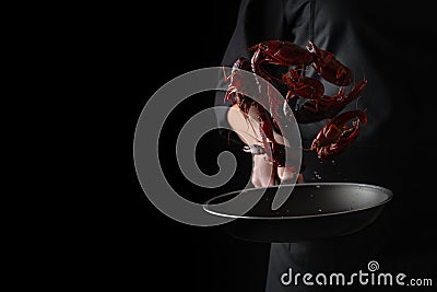 A professional chef cooks crayfish. Cooking seafood, healthy vegetarian food and meal on a dark background. Horizontal view Stock Photo